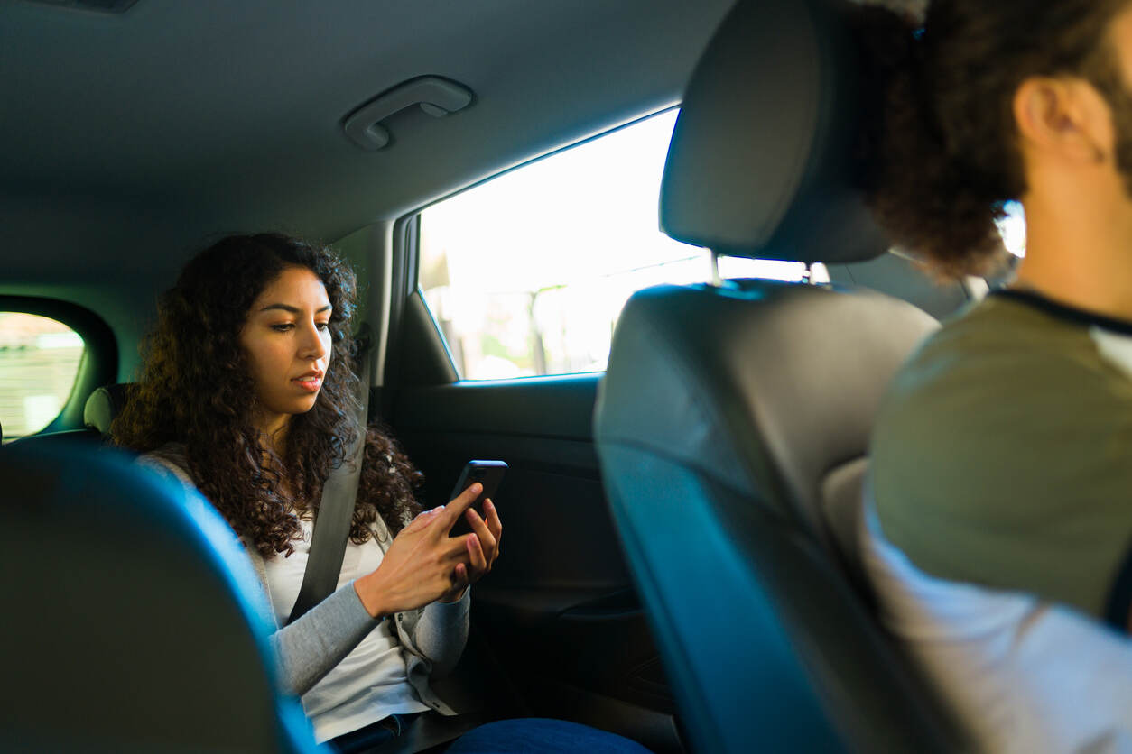 Teenager in a car's back seat, relevant to parents understanding California rideshare accident risks for minors.