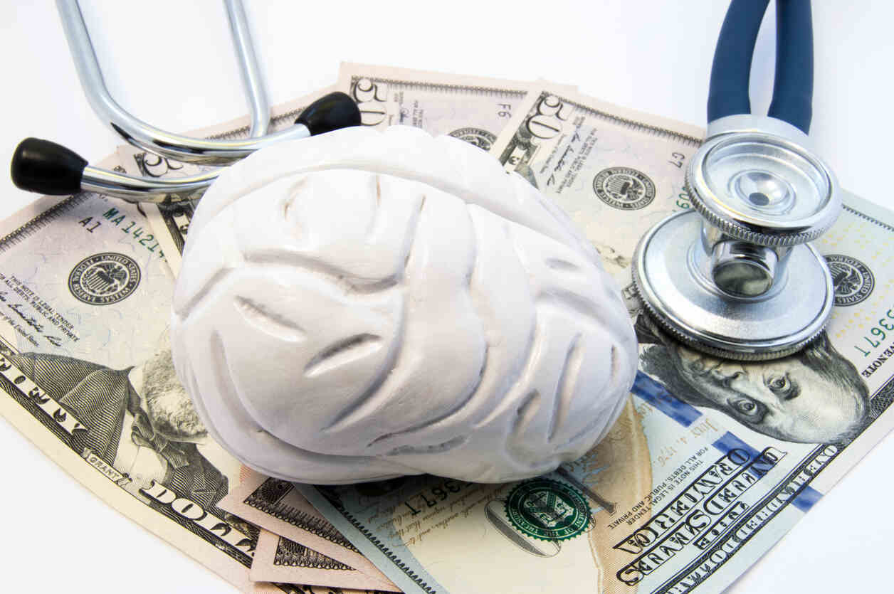 Image combining a brain, money, and a stethoscope, symbolizing the financial burden of TBIs and the role of California personal injury attorneys in securing compensation.