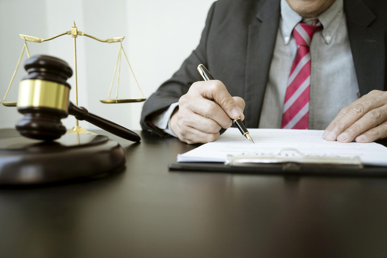 suited lawyer writing and gavel on the table representing San Diego Spinal Cord Injury Lawyers 