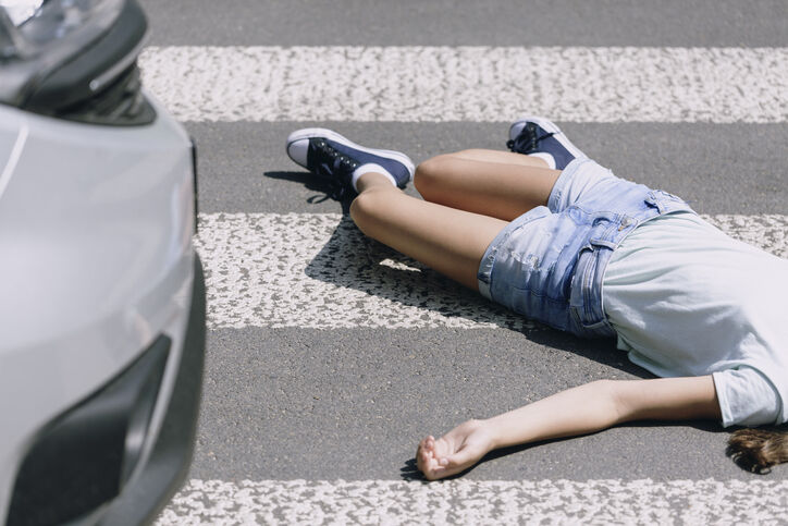 Pedestrian lying on a crosswalk after being hit by a car in California, highlighting the dangers of crosswalk accidents when drivers fail to yield to pedestrians.